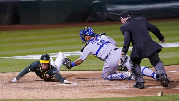 Jun 11, 2021; Oakland, California, USA; Oakland Athletics third baseman Matt Chapman (left) scores a run ahead of the tag from Kansas City Royals catcher Salvador Perez (13) during the ninth inning at RingCentral Coliseum. Mandatory Credit: Cary Edmondson-USA TODAY Sports
